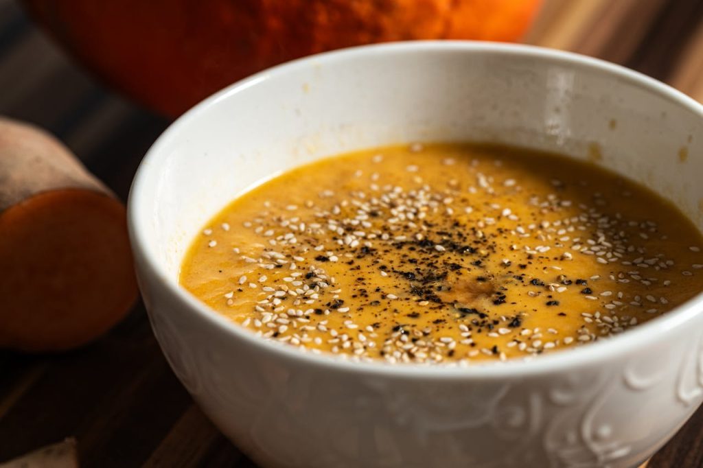 pexels photo 30624292 Warm pumpkin soup garnished with sesame seeds and pepper, perfect for a cozy meal.