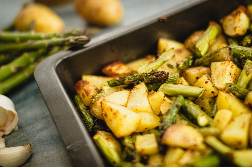 Delicious roasted potatoes and asparagus seasoned with spices, perfect for a vegan meal.